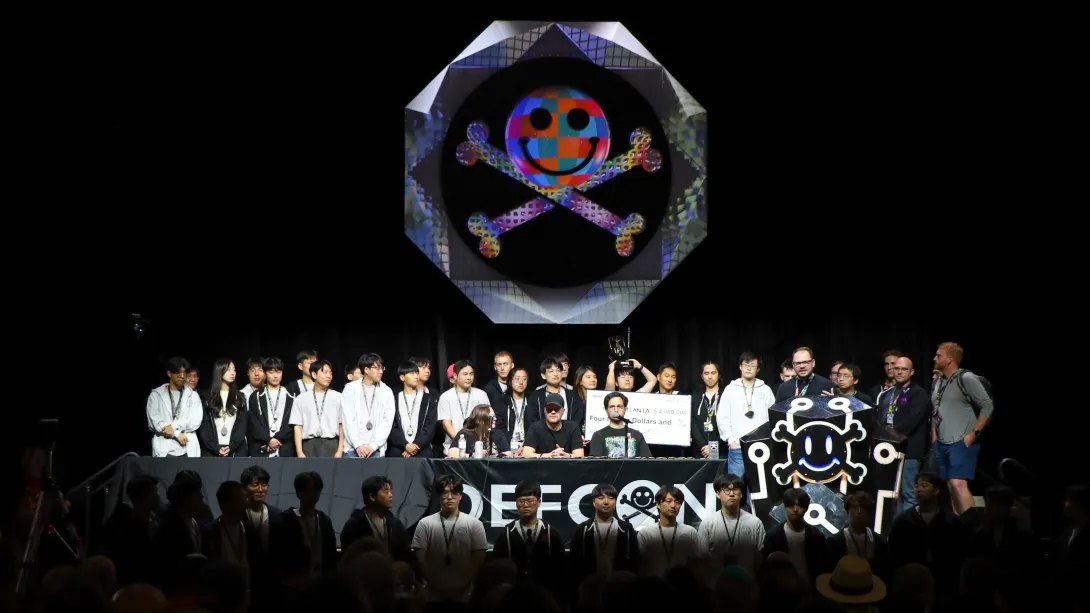 Team Atlanta stands on the dark DefCon stage during the convention&#039;s closing ceremony. 